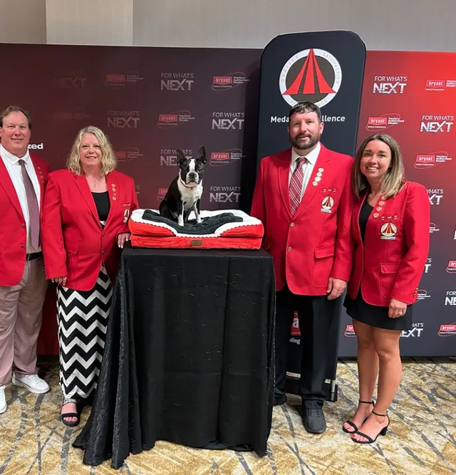 Bryant Medal of Excellence award presentation with the team in red Bryant blazers