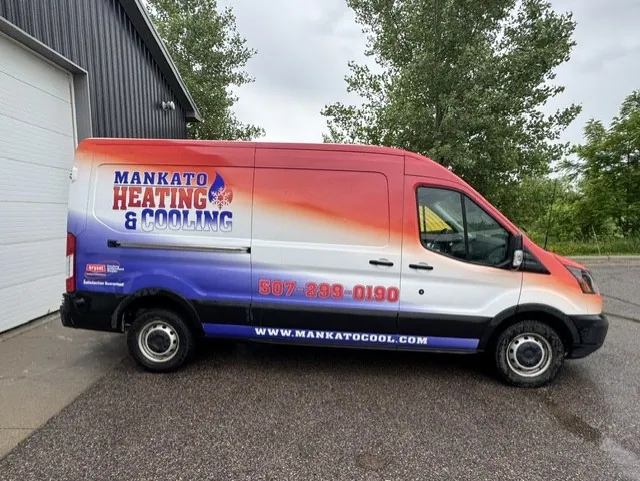 A Mankato Heating & Cooling service van parked outside the company building